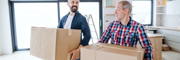 A senior man helping his son with furnishing new house, a new home concept.